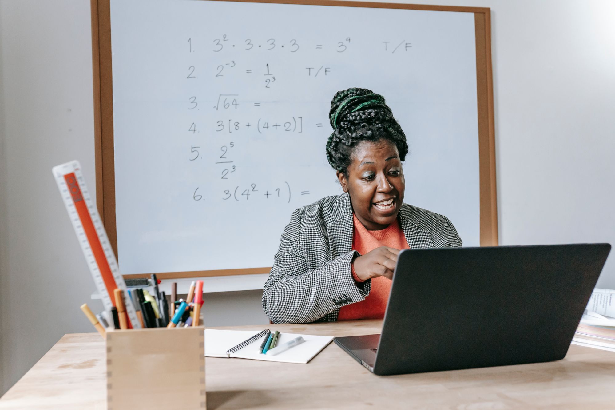 Educator teaching an online mathematics lesson using a laptop