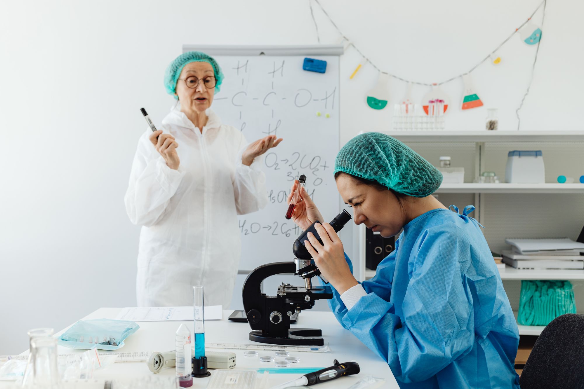 A science instructor guiding a learner at a laboratory microscope